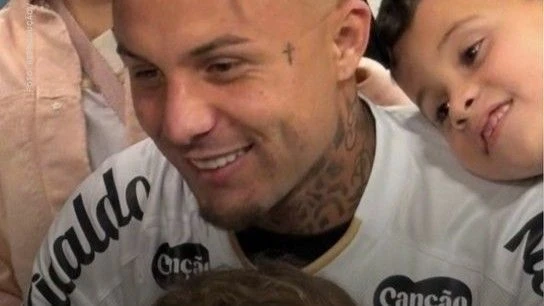 Cebolinha veste a camisa do Santos após desembarque em aeroporto